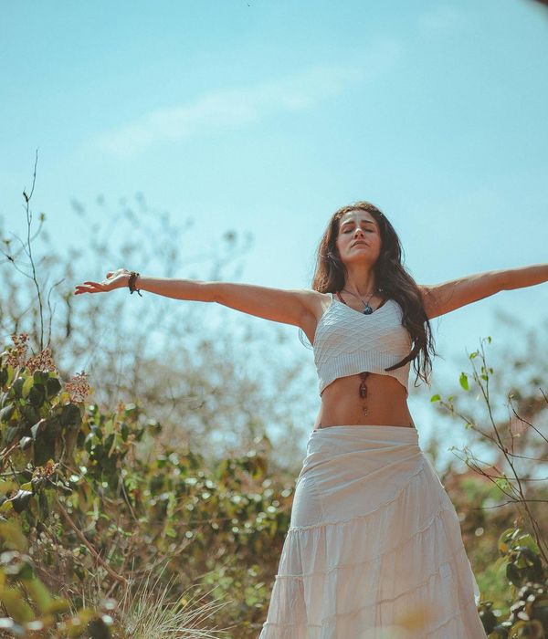 Person in a calm meditation pose surrounded by nature.